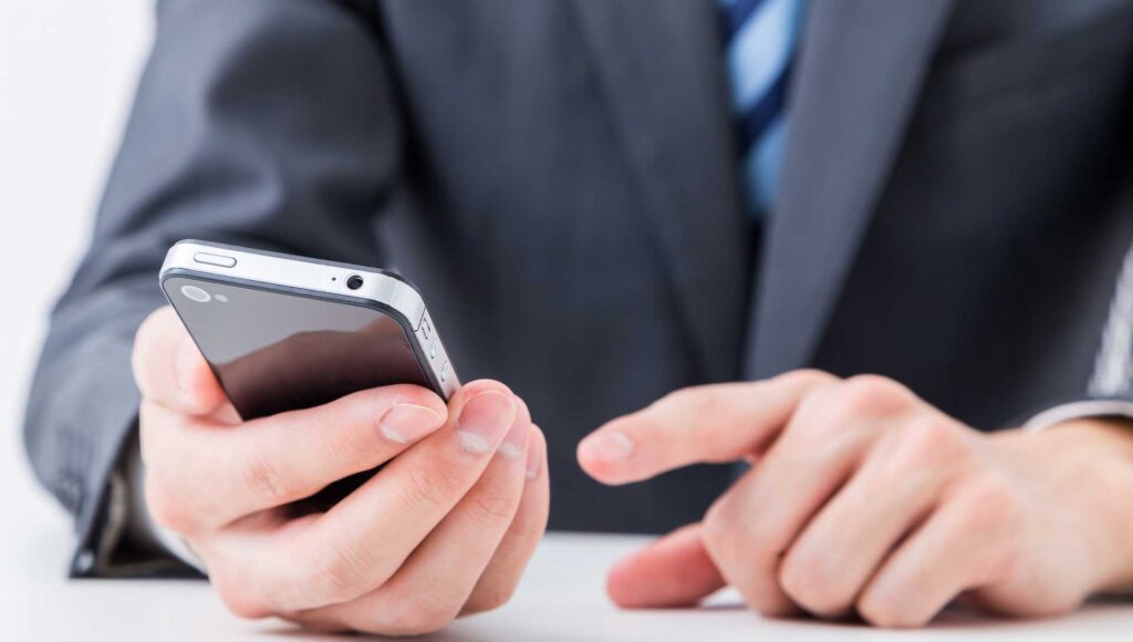 スマートフォンでFXをする男性のイメージ